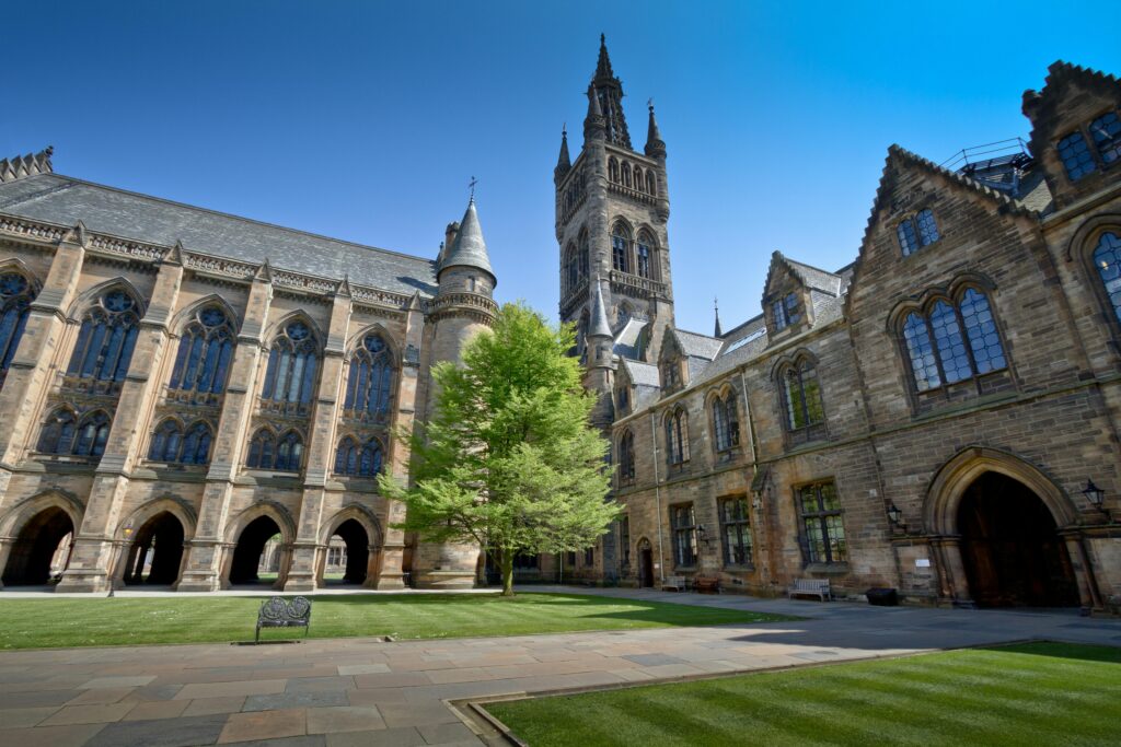 masterclass View of the stunning historic University of Glasgow courtyard under a clear blue sky.